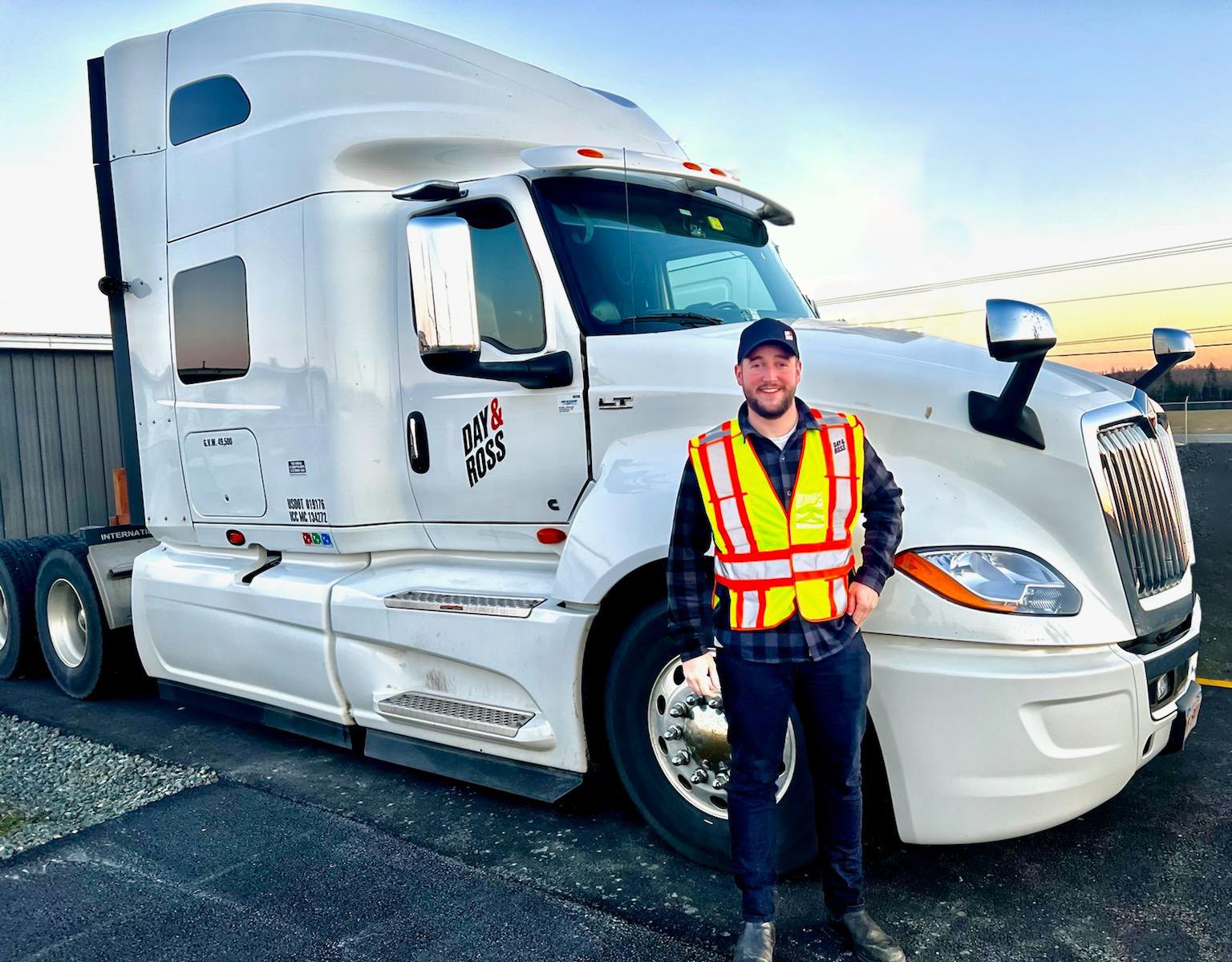 Happy driver standing beside company truck